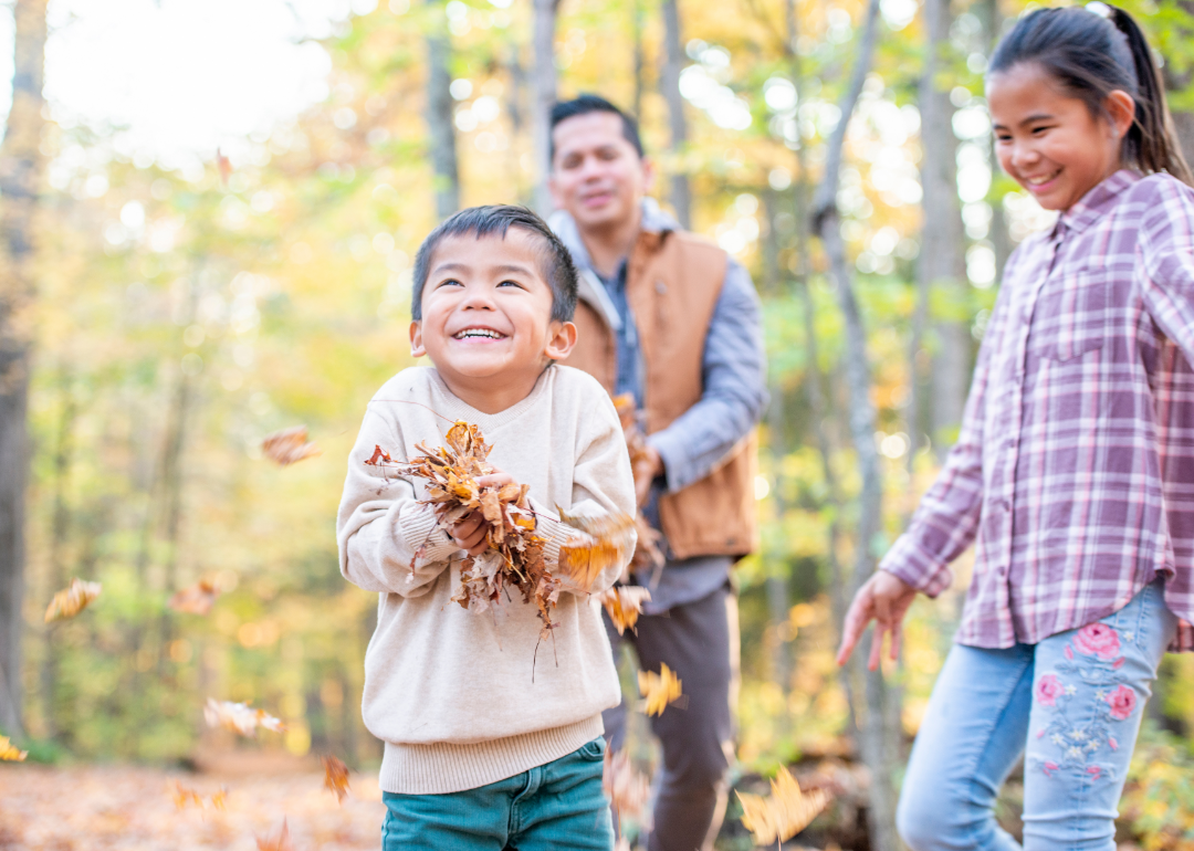 Family playing in the leaves in the fall