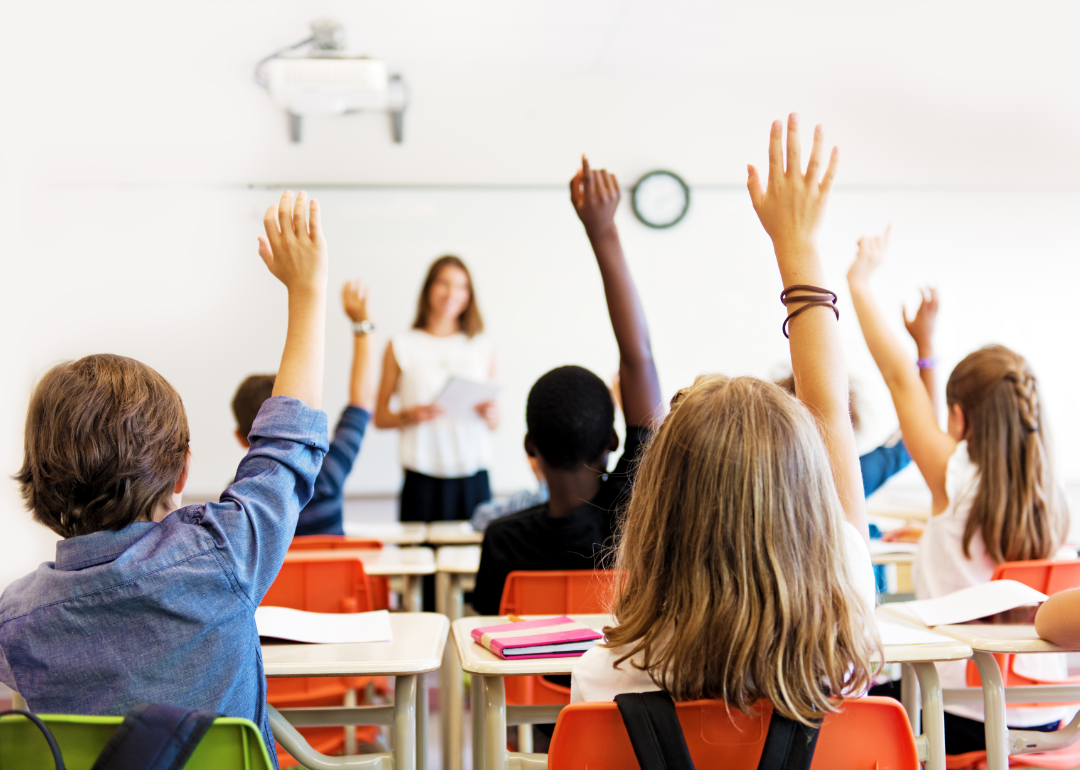 Students raising their hands in the classroom