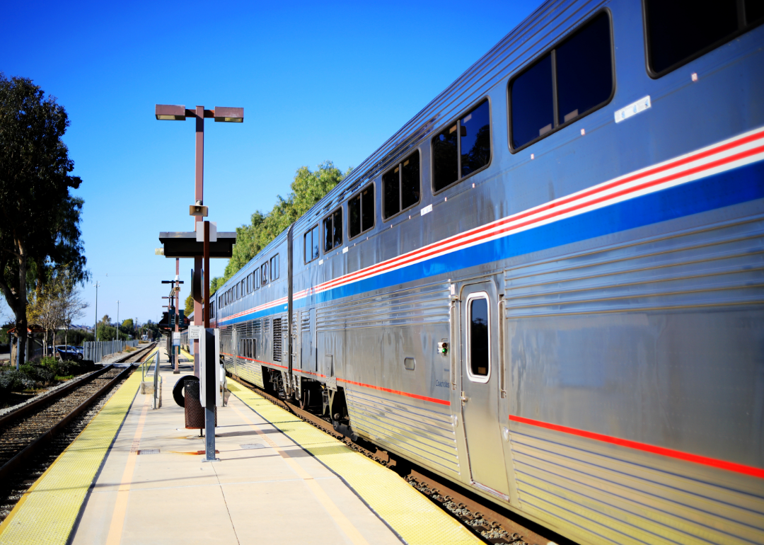 An Amtrak train waits on the tracks at a small train station