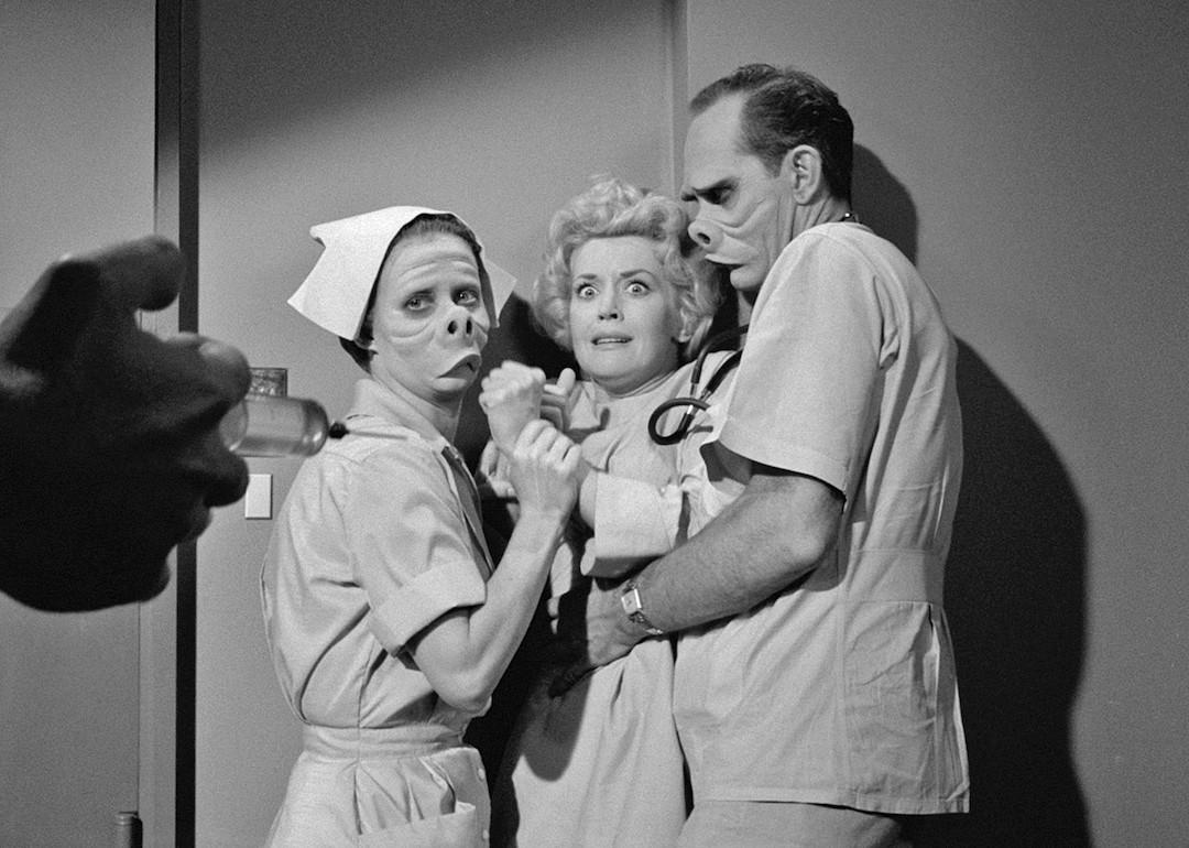 A scene from the "Eye of the Beholder" episode of "The Twilight Zone" where a woman is being restrained as a syringe approaches.