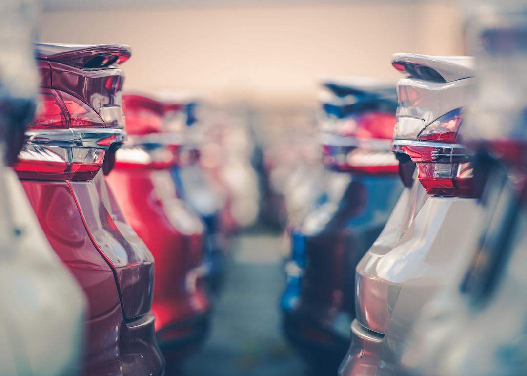 Closeup of the back of cars in a row in a car dealership.