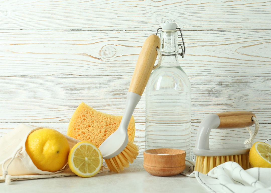 Scrubbers sit on a counter with lemons and reusable cleaning bottles.