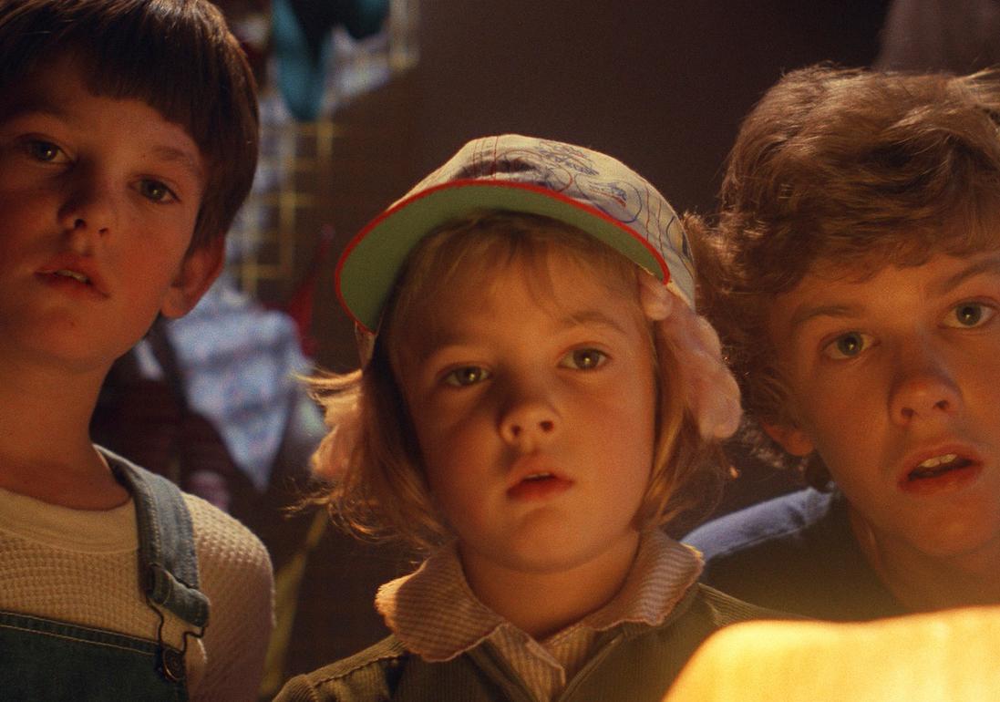 Henry Thomas as Elliott, Drew Barrymore as Gertie, and Robert MacNaughton as Michael looking shocked in the 1982 sci-fi movie 'E.T. the Extra-Terrestrial.'