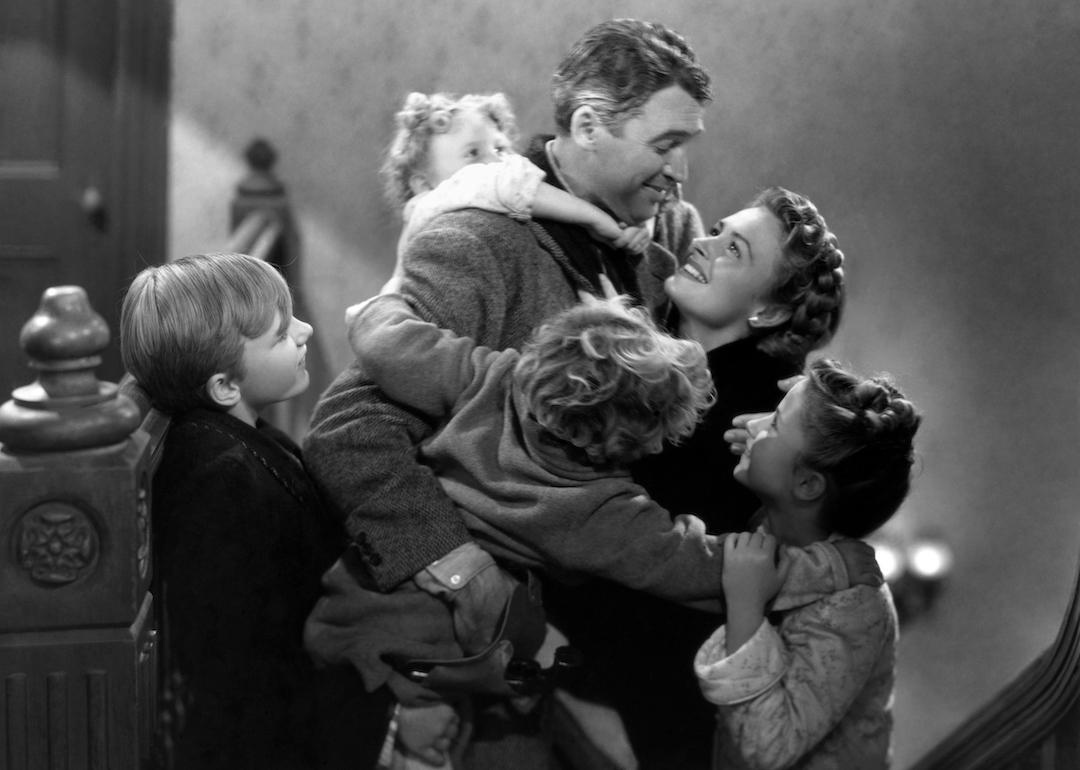 ames Stewart, Donna Reed, Carol Coombs, Jimmy Hawkins, Larry Simms, and Karolyn Grimes embrace in the classic black-and-white Christmas movie 'It's a Wonderful Life.'