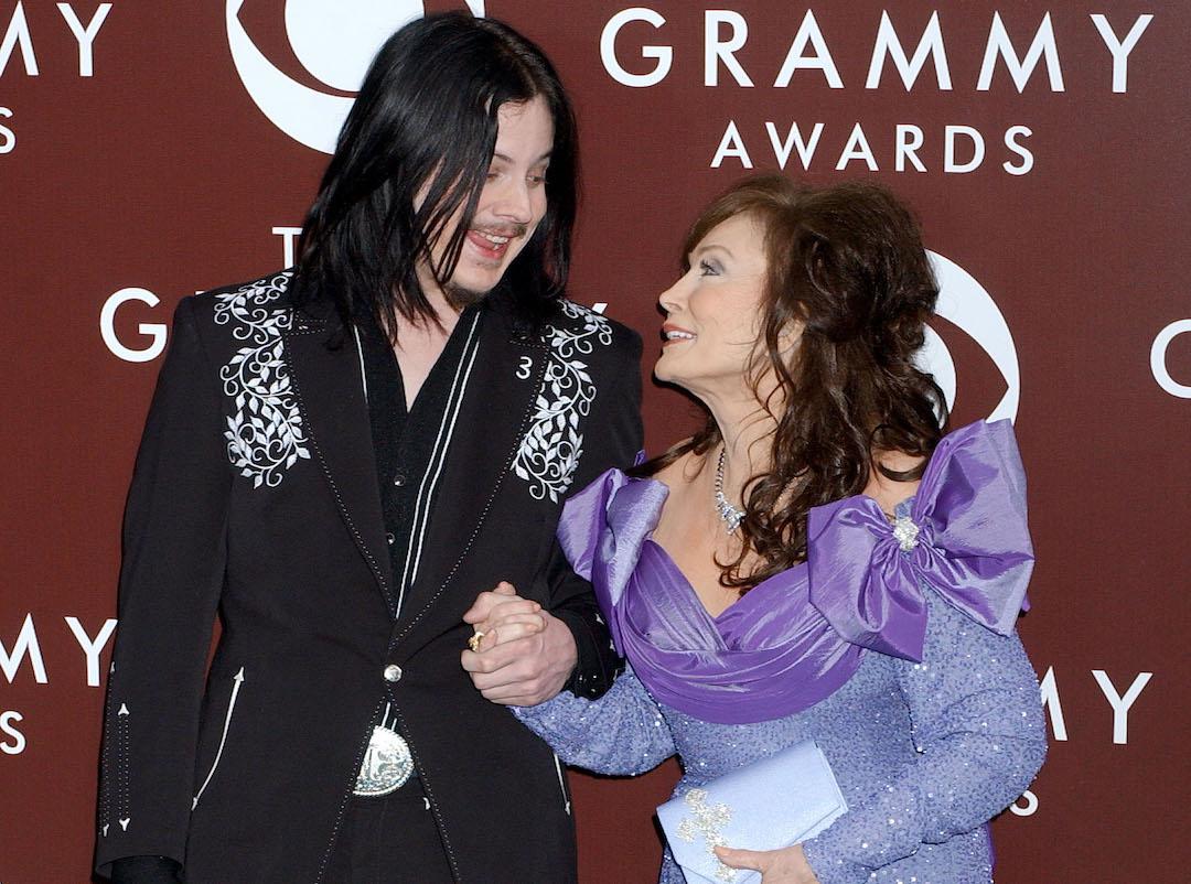 Jack White and Loretta Lynn hold hands while promoting their album 'Van Lear Rose' at the 47th annual Grammy Awards.