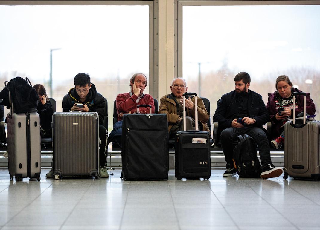 Passengers seated in the airport terminal waiting for their flights during Christmastime.