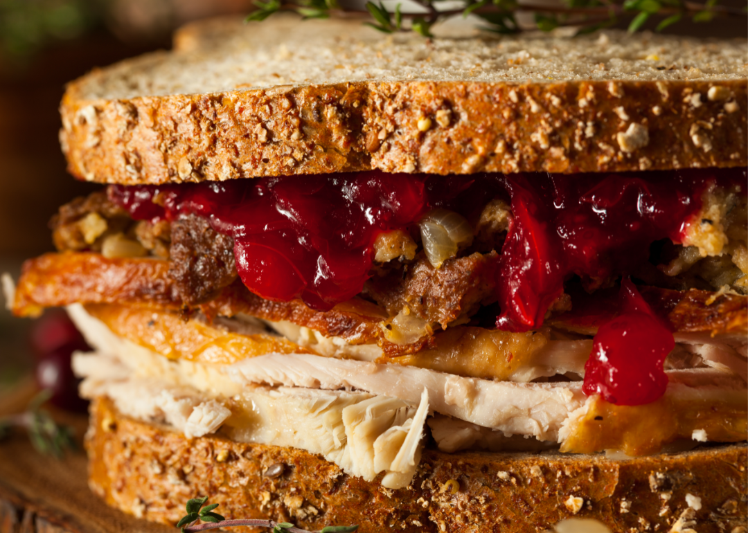 Homemade leftover Thanksgiving sandwich with turkey, stuffing, and cranberry sauce.