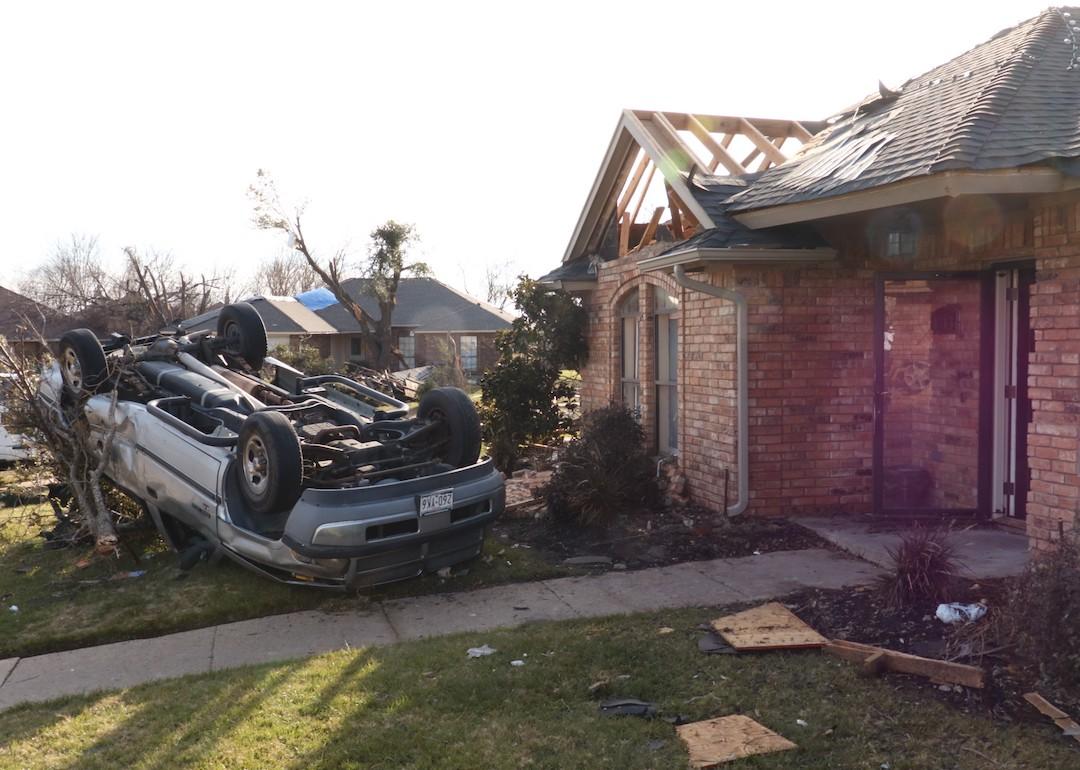 Damaged car and home after a tornado hit Dallas on Dec. 31, 2015.