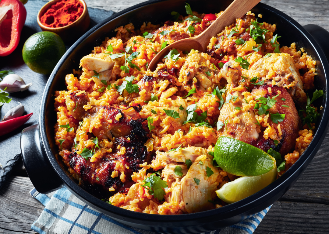 Arroz con pollo, white long grain rice with chicken and vegetables, in a cast-iron skillet.
