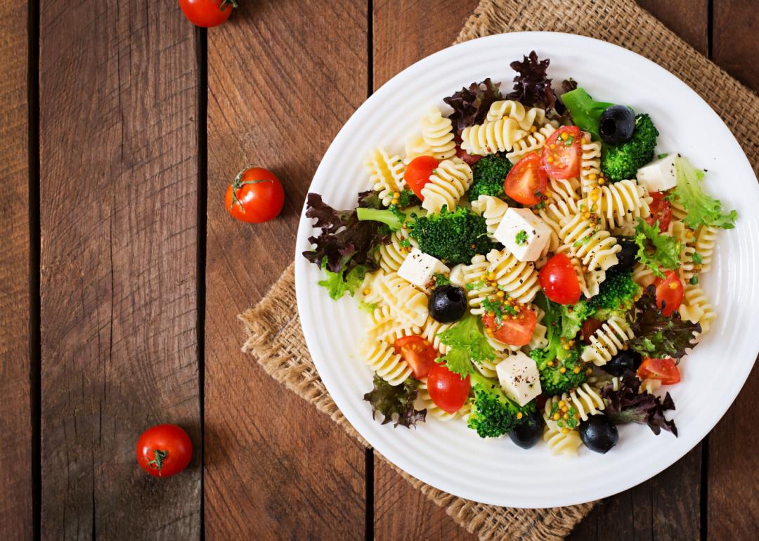 Pasta salad with tomato, broccoli, black olives, and feta cheese.