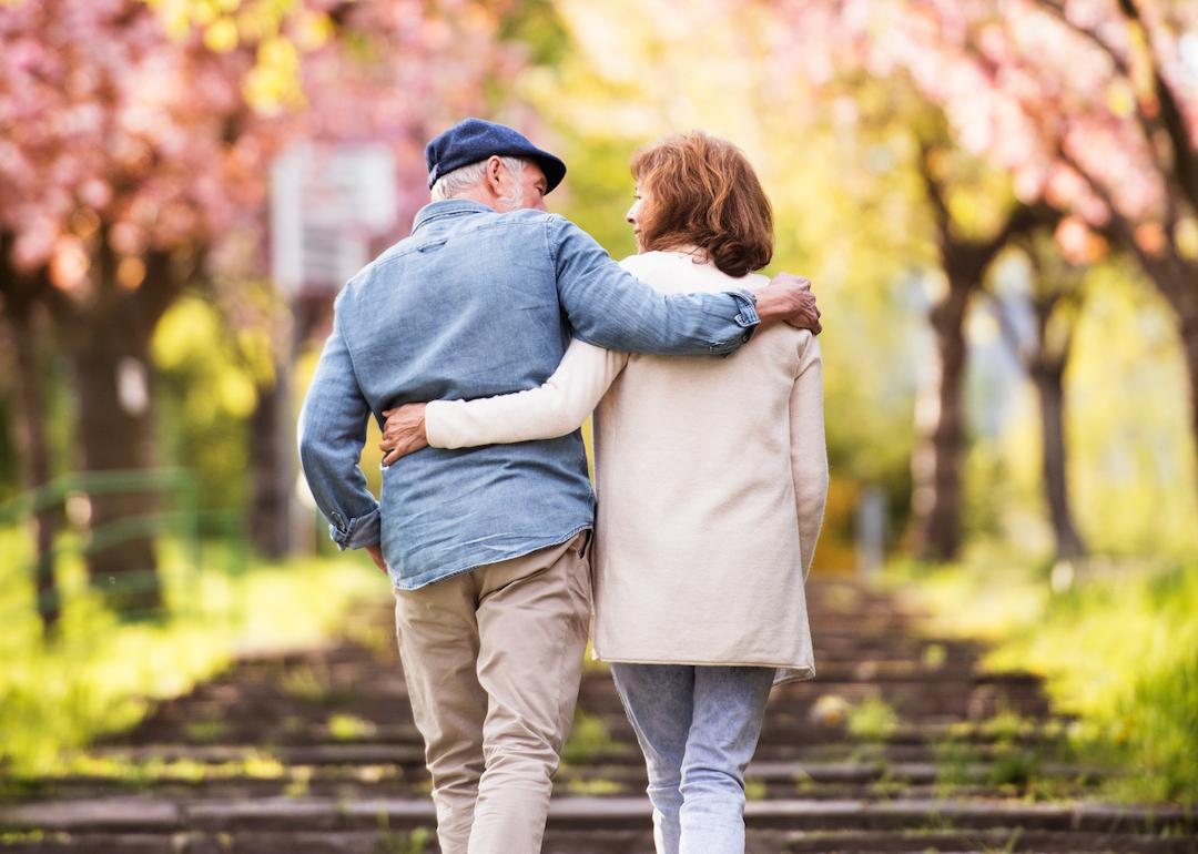 Senior couple embrace during a springtime walk.