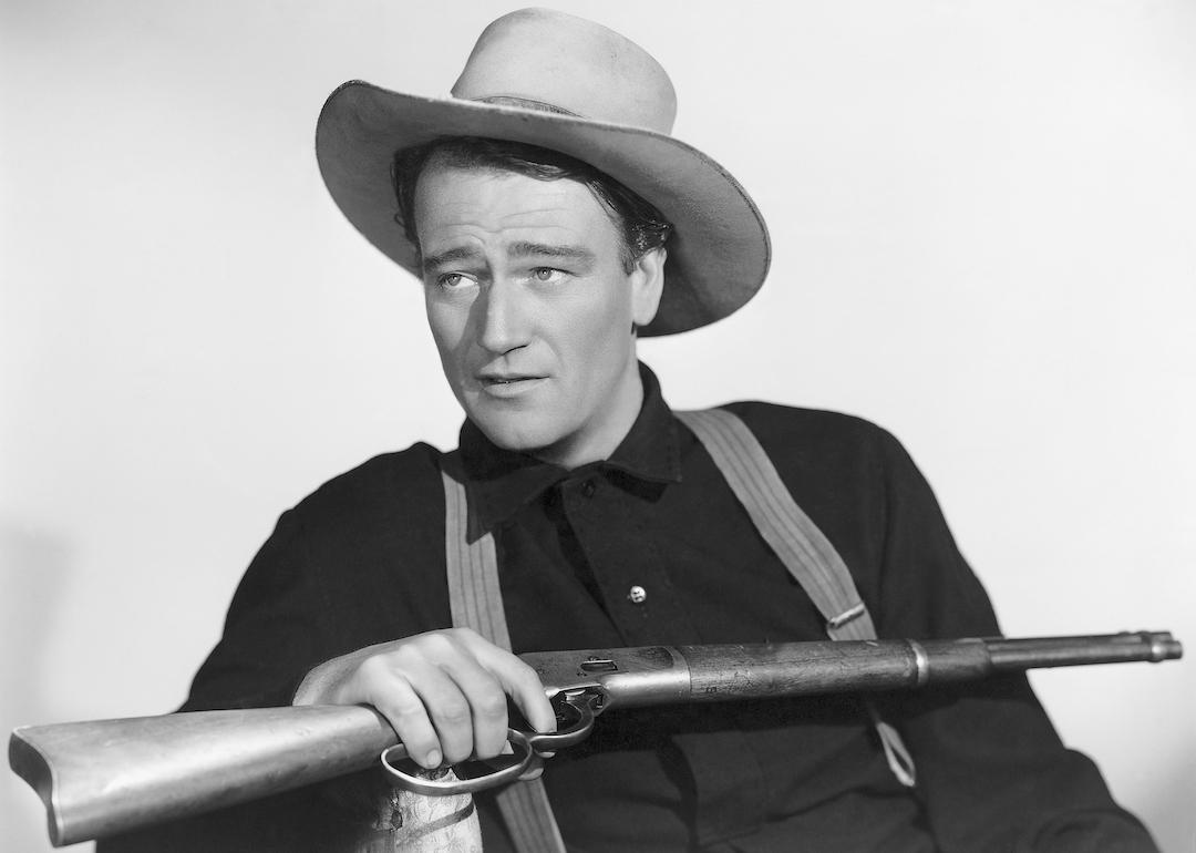 Actor John Wayne holding a rifle in a publicity photo for the movie 'Shepherd of the Hills.'