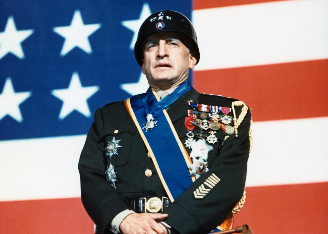 Actor George C. Scott in uniform stands in front of an American flag in 'Patton.'