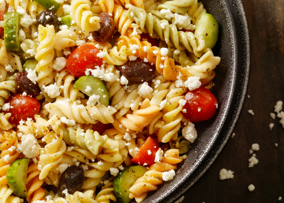 Greek pasta salad with tomato, black olives, cucumber, and feta cheese.
