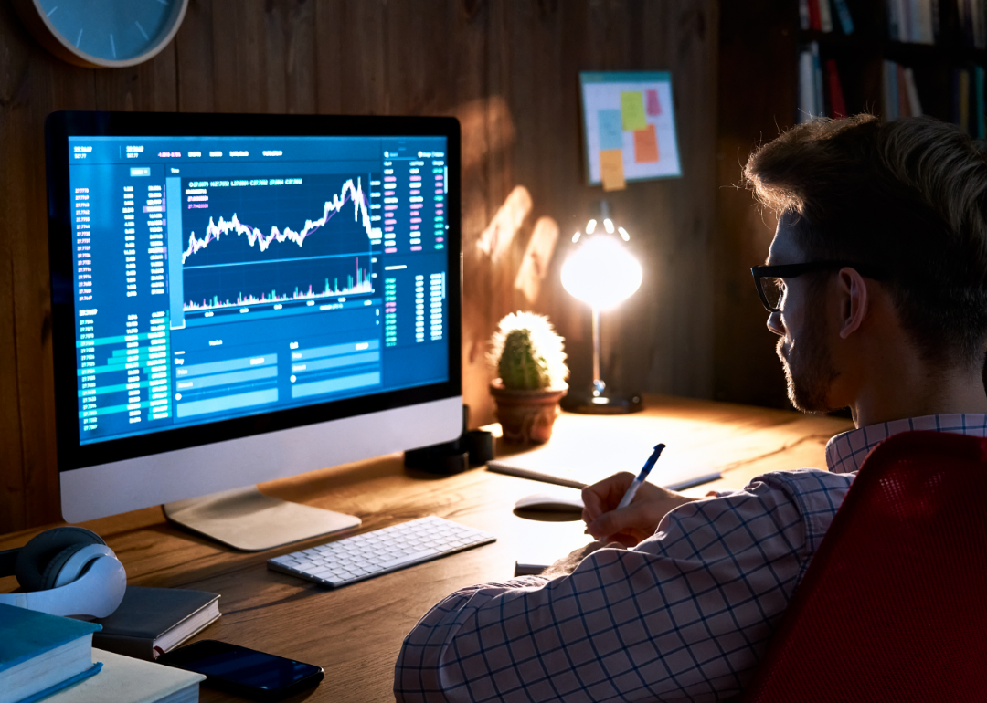 A stock market analyst at work in the evening.