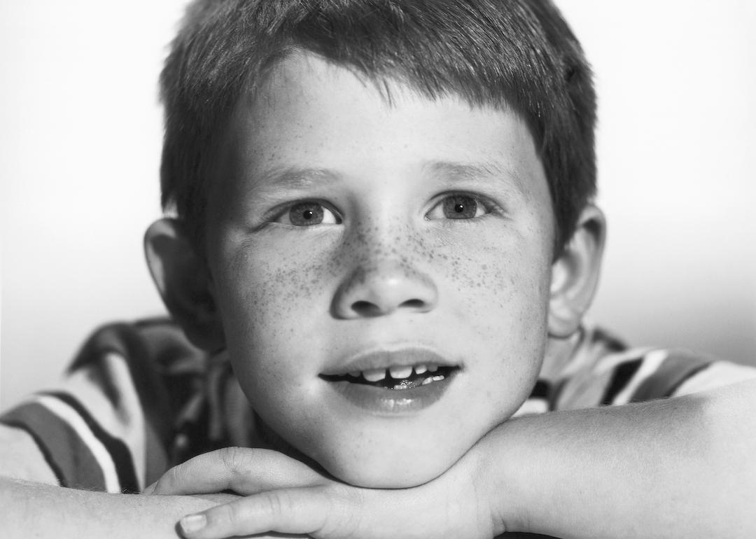 Child star Ron Howard wears a striped shirt and rests his head on his hands in a 1962 photo.