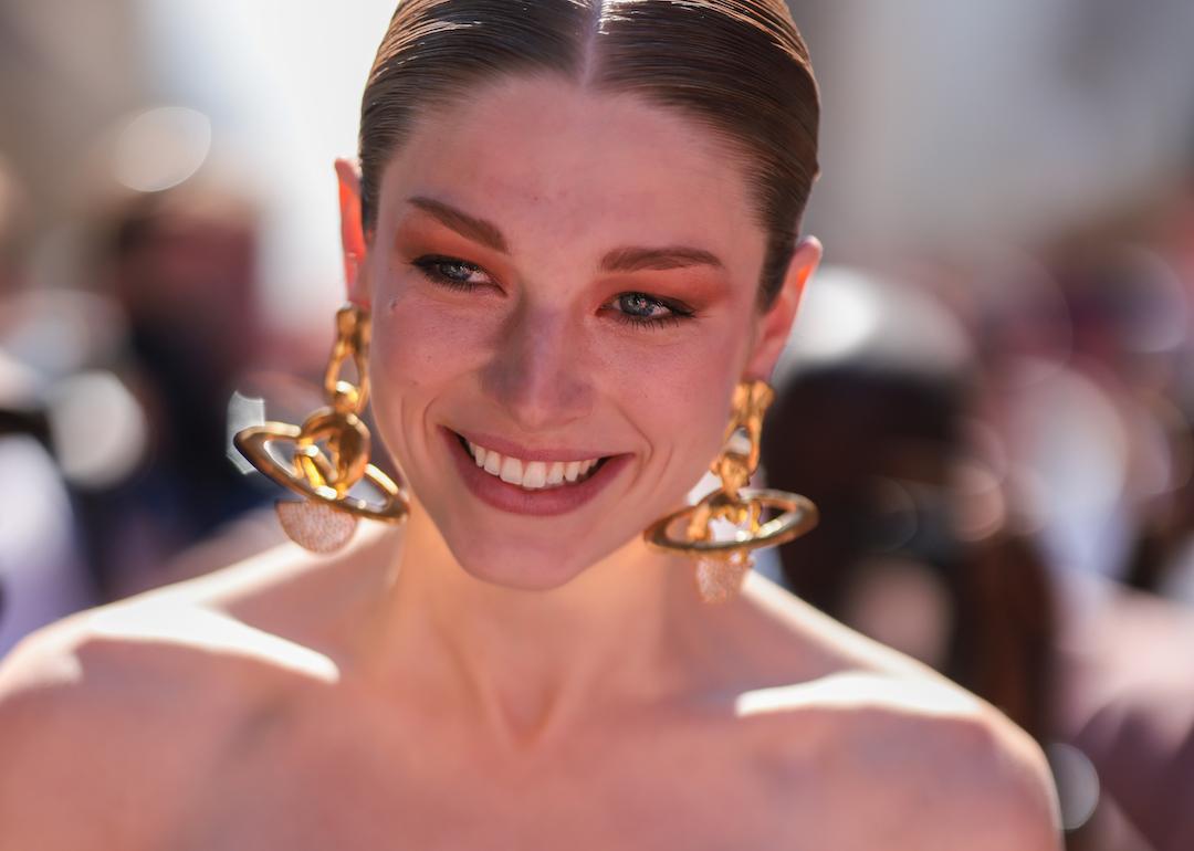 Model and 'Euphoria' actor Hunter Schafer seen wearing gold pendant earrings, a black off-shoulder corset top and black long velvet gloves, outside the Schiaparelli show, during Paris Fashion Week in July 2022.