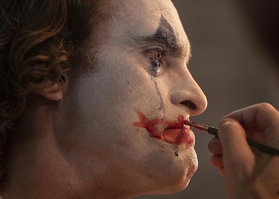Actor Joaquin Phoenix puts makeup on his face in the 2019 movie 'Joker.'