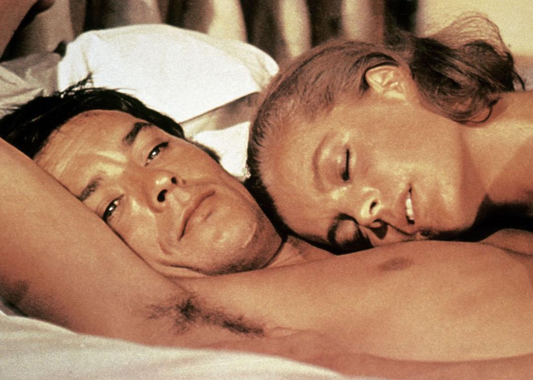 Alain Delon as Jean-Paul and Romy Schneider as Marianne laying by the pool in the movie 'La Piscine.'