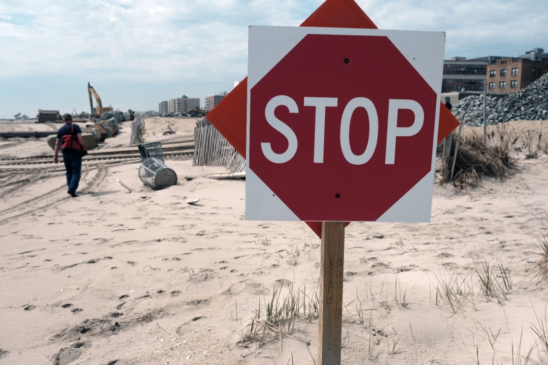 A stop sign on a beach.