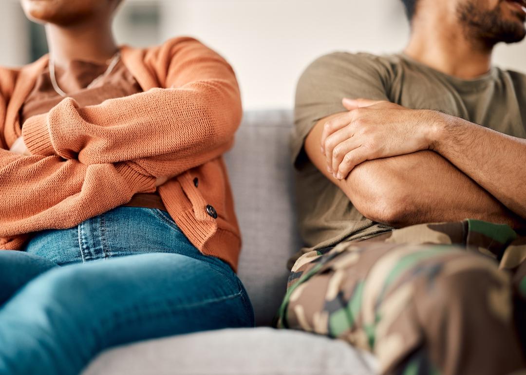 Couple on sofa with their arms folded.