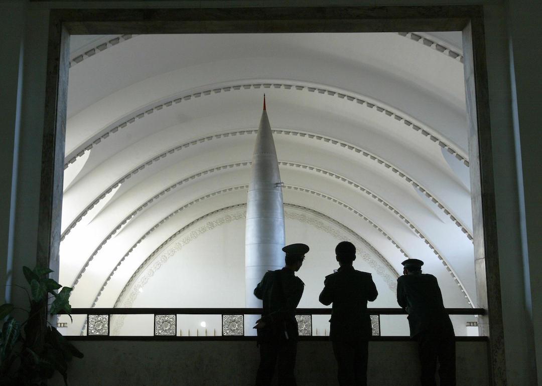 Chinese People's Liberation Army soldiers take in the view from a balcony at the Military Museum in Beijing of a Chinese-made Dongfang-1 missile on display.