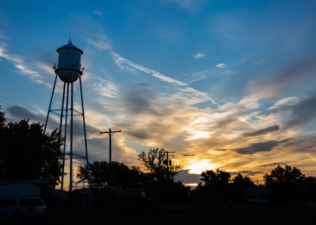A water tower in a small American town seen at sunset