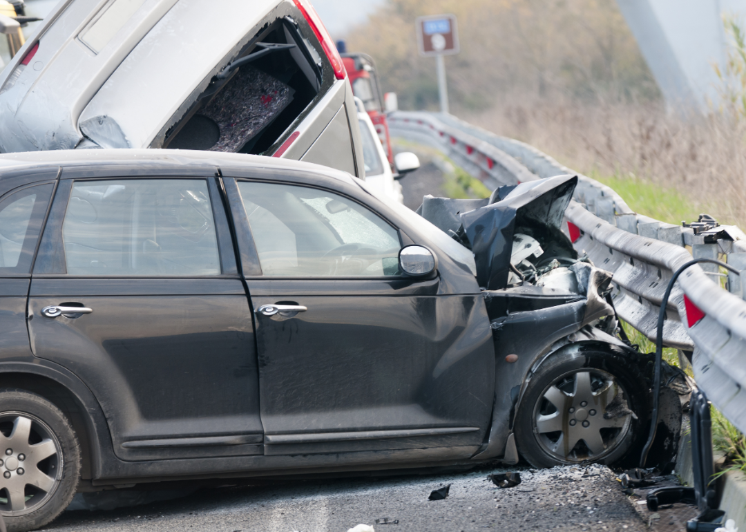 Black car and silver truck involved in an accident on a highway.