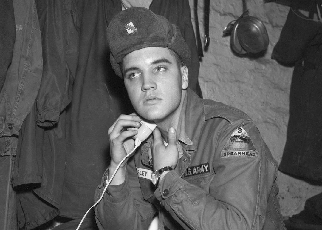 A portrait of Elvis Presley in his military uniform shaving at the maneuver camp Grafenwoehr in Germany.