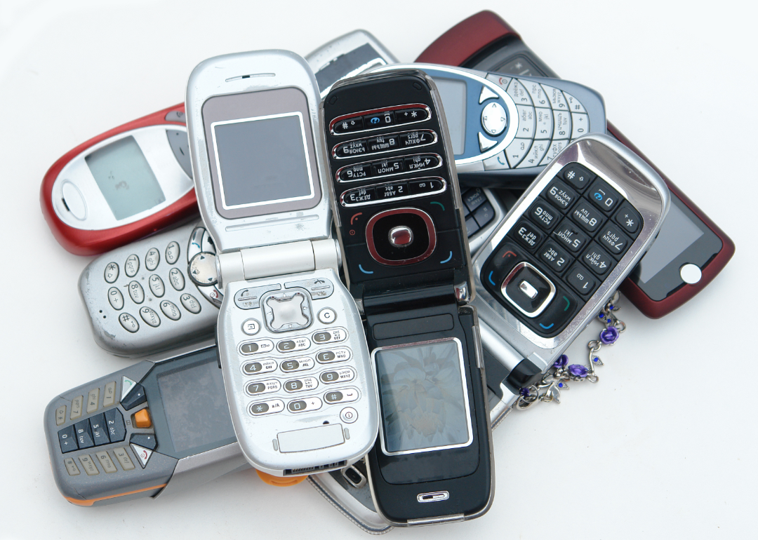 A collection of old cellphones against a white background
