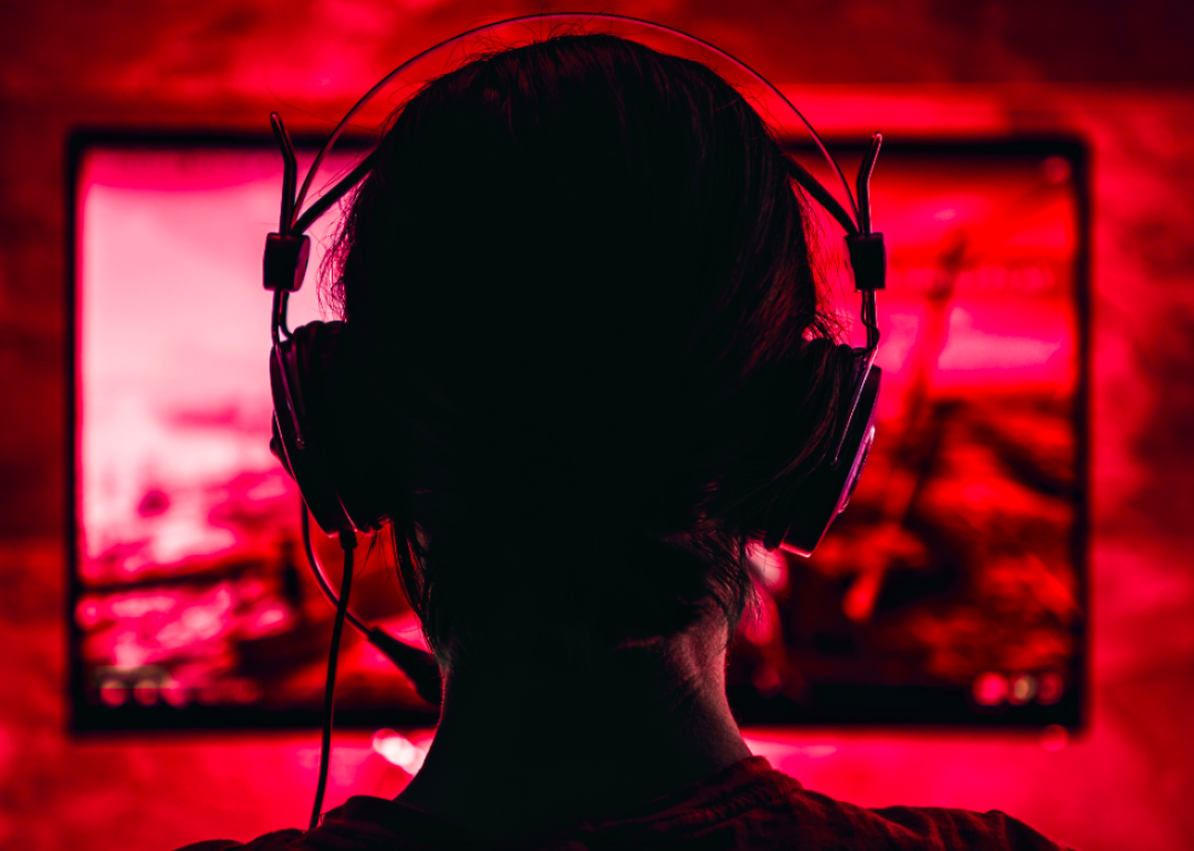 A woman wearing headphones and playing a video game.