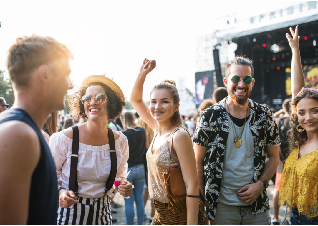 A group of young men and women smiling and dancing outdoors