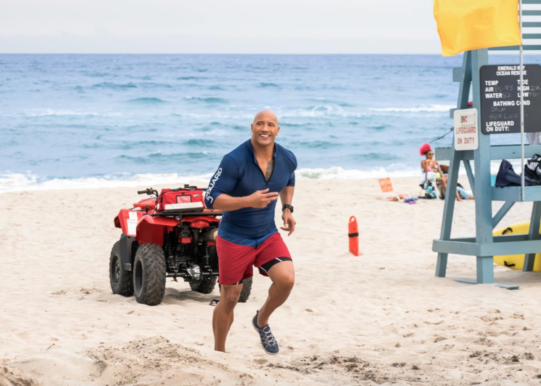 Dwayne Johnson running on a beach in a scene from "Baywatch" (2017)