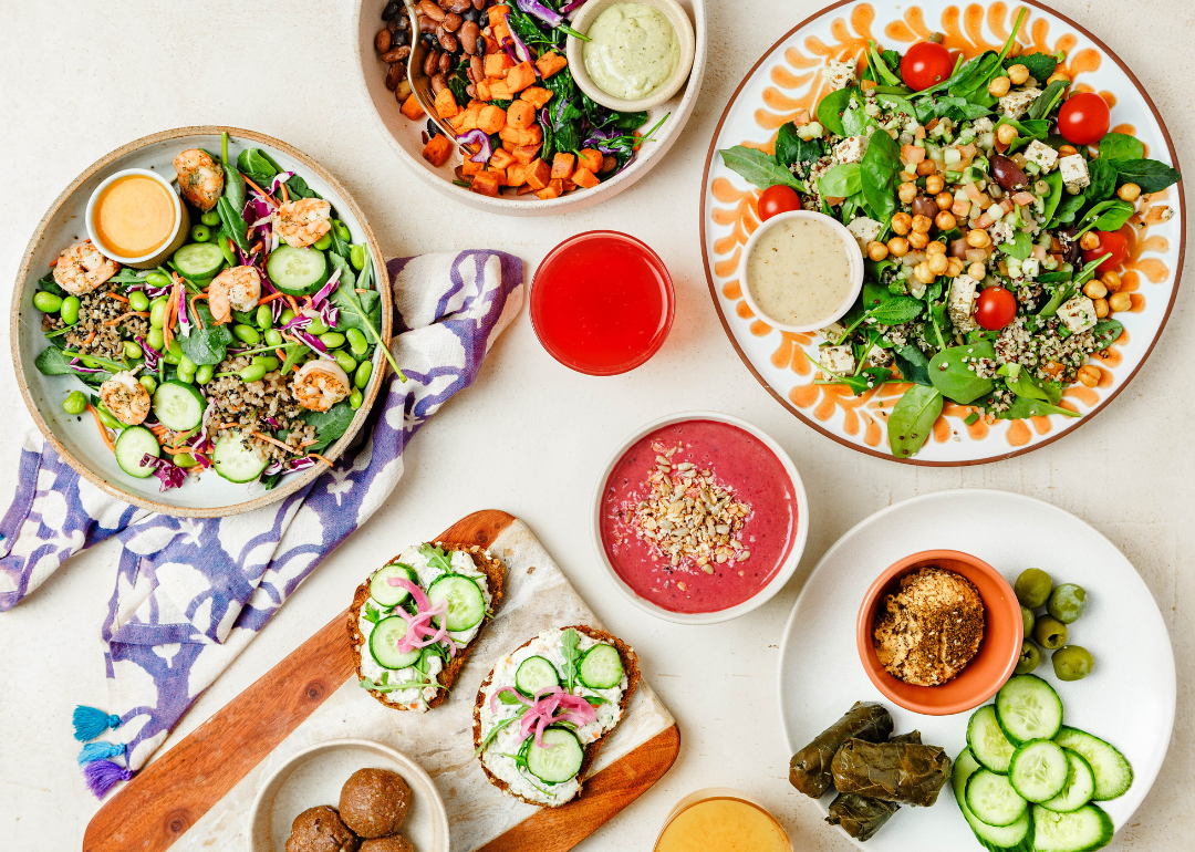 An overhead view of a variety of plant-based foods on a white surface.