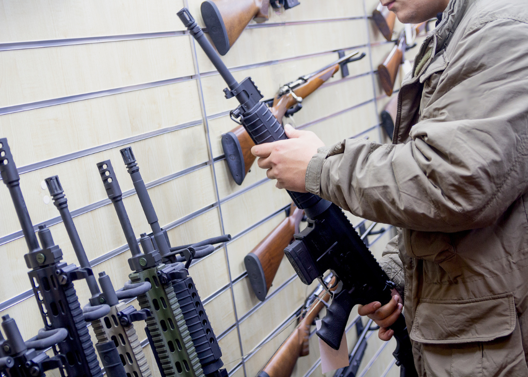 Man checking out an automatic rifle at a store