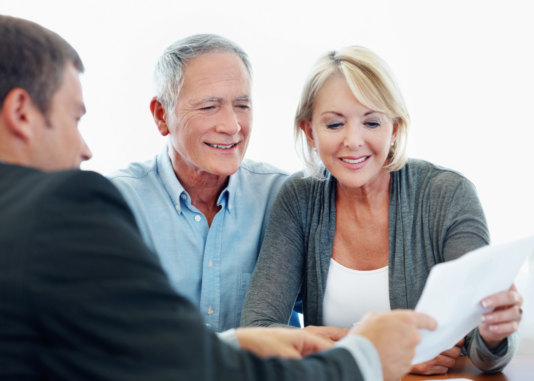 A older couple sit with a financial advisor and go over some paperwork