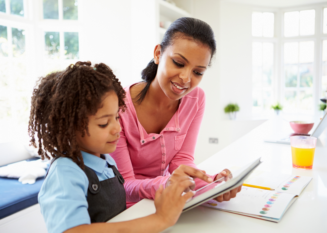 A Black mother teaching her daughter financial literacy.