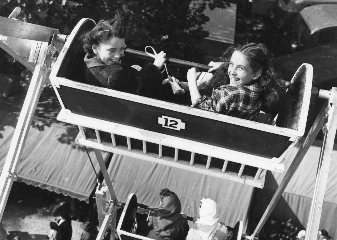 View (from above) of two kids looking back at the camera during a Ferris wheel ride at a county fair in Lancaster, Ohio in 1949.