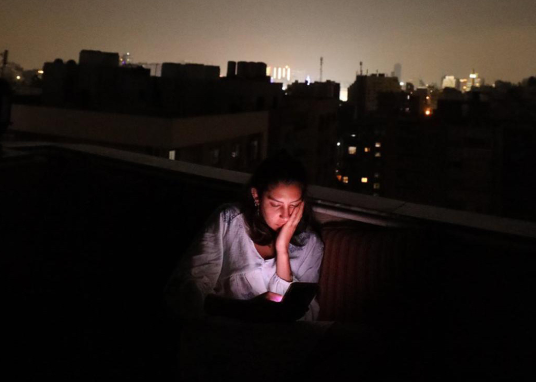 Mirna El Helbawi at her home in Cairo, Egypt, during a temporary blackout. She has been working around the clock to distribute eSIMs to Palestinians in Gaza.