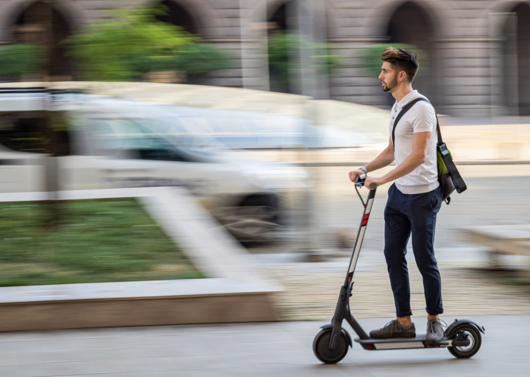 A man rides an e-scooter in a city