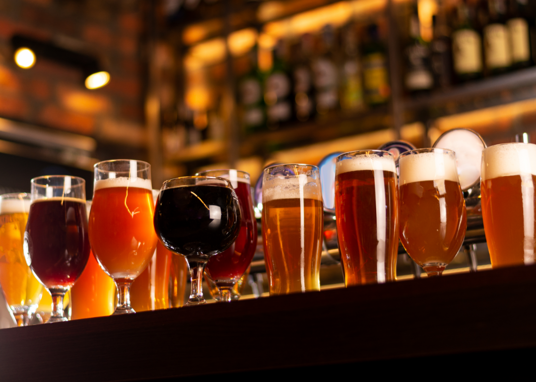 An assortment of glasses and mugs of various craft beers on a bar table