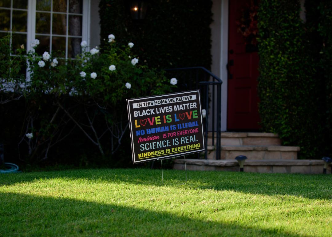 Lawn of a house in an Los Angeles suburb with a sign with messages of equality