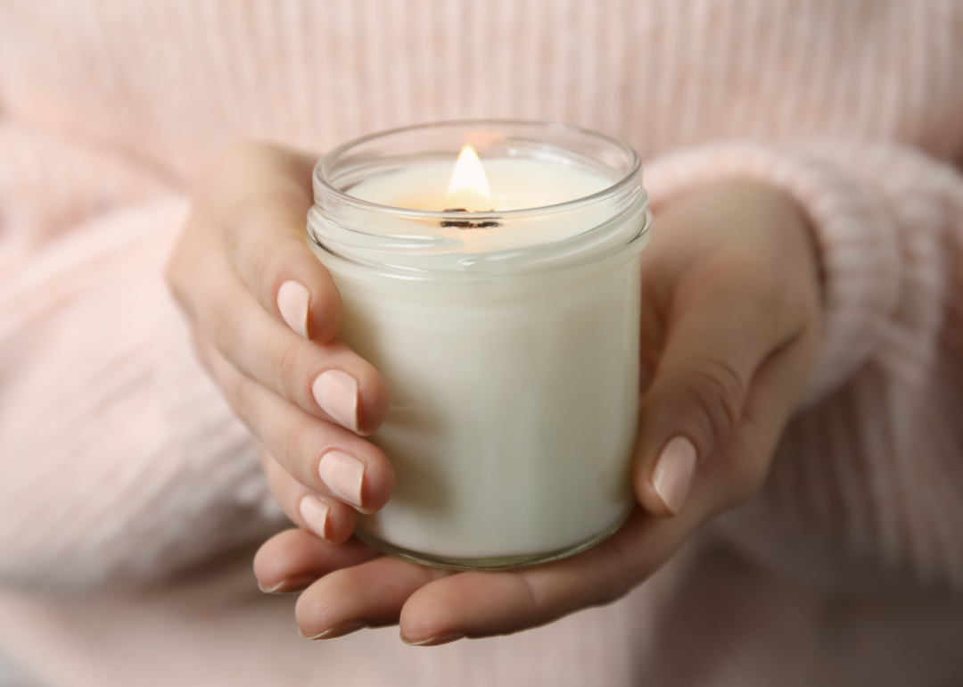 A woman's hands holding a small white candle
