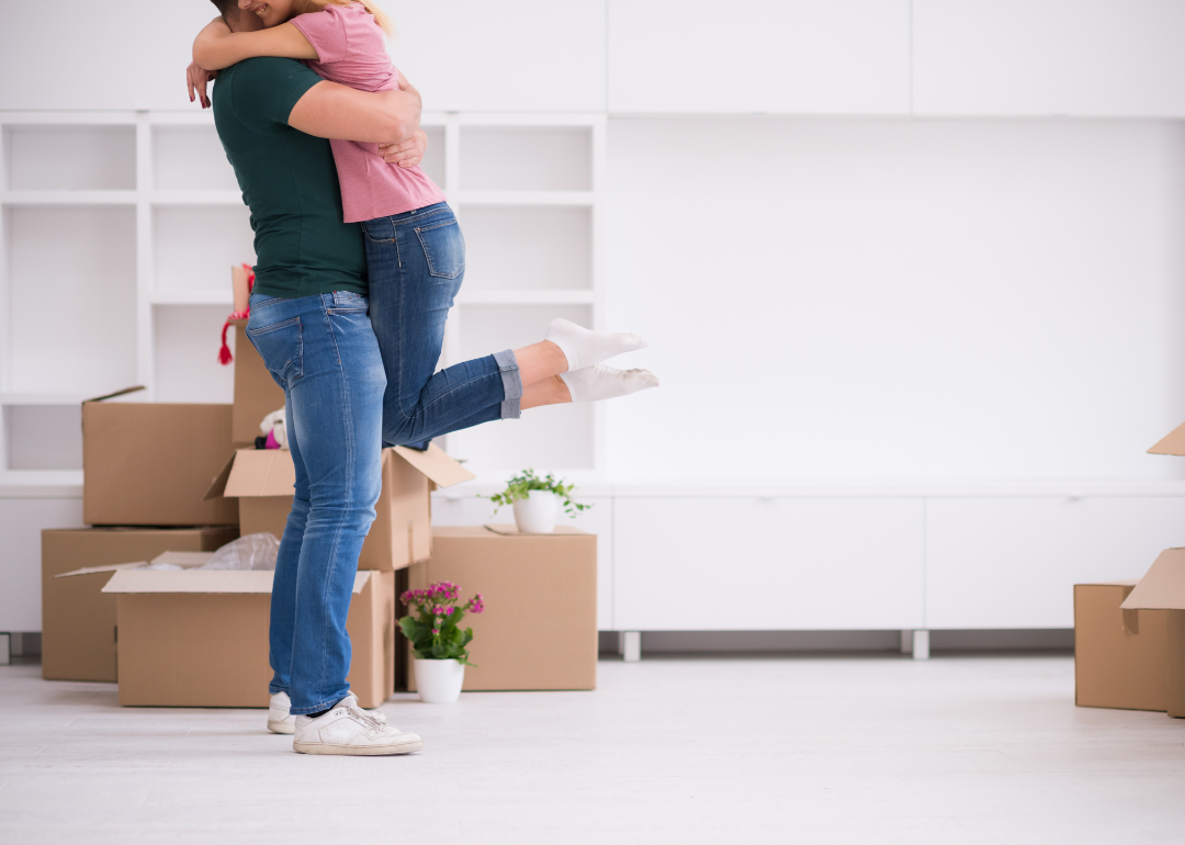 A young couple hug as they move into a new home