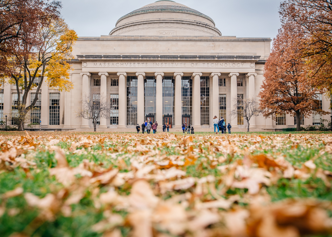 A landscape shot of one of the buildings on the Massachusetts Institute of Technology campus on a late autumn day with fallen leaves in the foreground