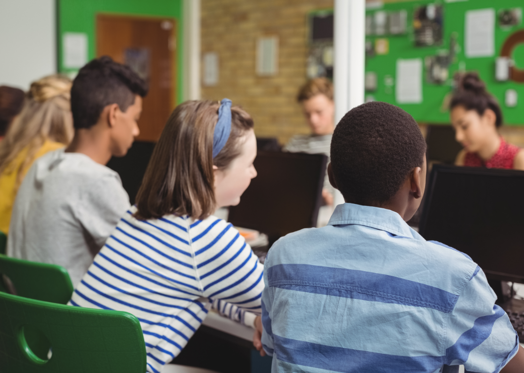 A group of students viewed from behind in a classroom setting.