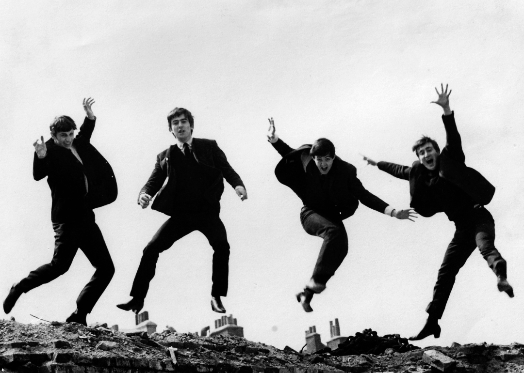 Photo of the Beatles, April 1963; L-R: Ringo Starr, George Harrison, Paul McCartney, John Lennon - are jumping on top of a brick wall