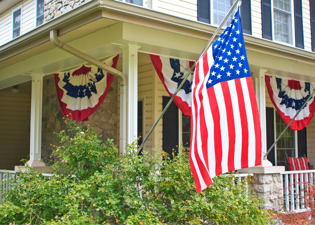 The front porch of a patriotic bed and breakfast inn in Oklahoma is proudly festooned with an American flag and banners.