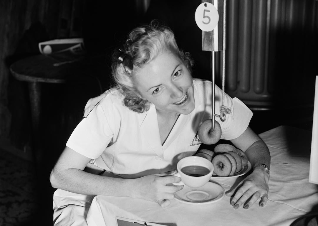 Beryl Holmquist demonstrates the 'Commuter's Friend,' a device that permits someone to read their newspaper at the breakfast table while dunking their doughnuts.