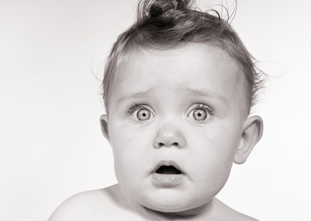 Wide-eyed baby from the 1950s looking at the camera.